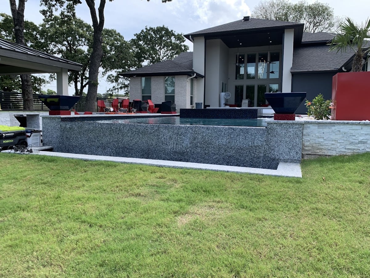 Custom gunite pool with elevated spillover edge and fire bowls built by Platinum Pools in Trophy Club TX